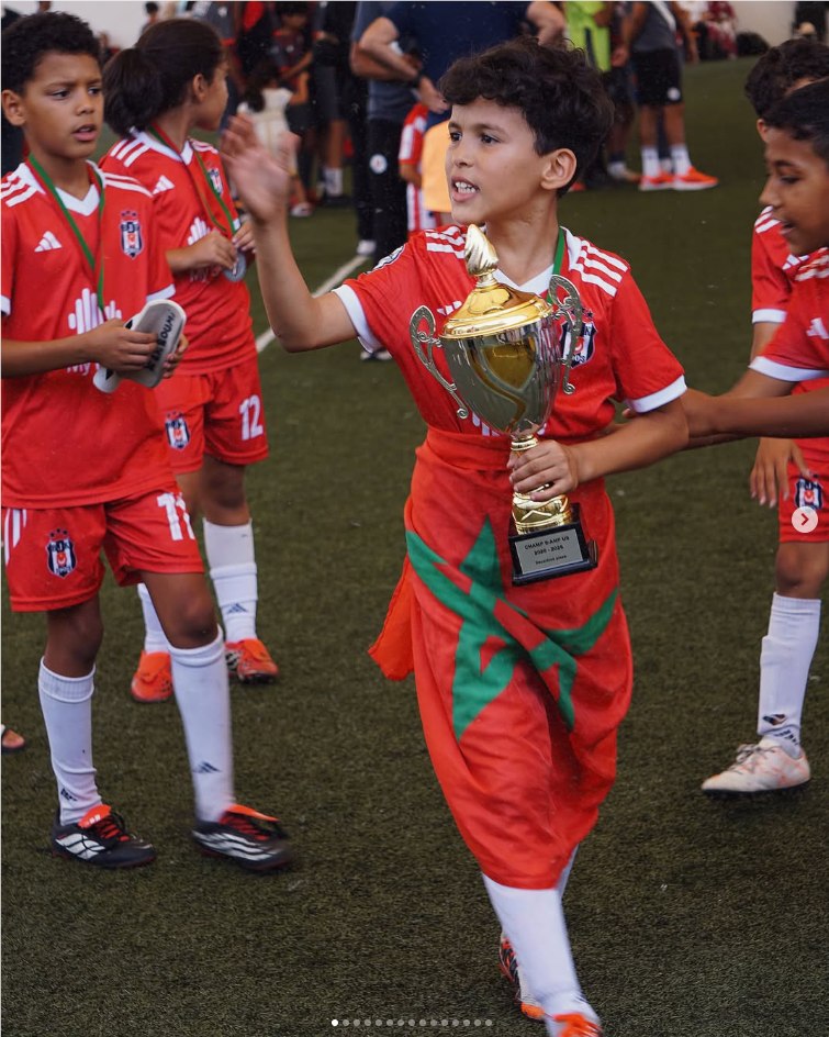 Jeune joueur de l’académie portant un trophée